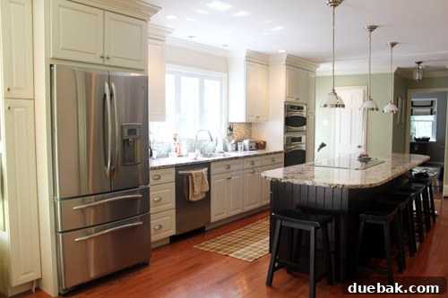 Beautifully renovated open concept living space with modern kitchen, new windows, stylish lighting, and elegant decor