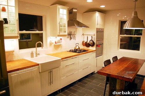Renovated kitchen showing new IKEA cabinets, sleek appliances, and open shelving