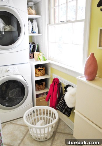 Streamline Your Laundry and Mudroom 7 Various coats and accessories hanging neatly on a white coat rack in a clean laundry room.