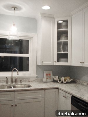 From Drab to Fab: Our Kitchen Renovation 6 Close-up of a kitchen corner with an elegant glass-front cabinet and decorative accents