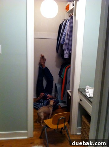 January Standouts 2 John in an awkward pose taking photos of the closet chandelier, supervised by Burger