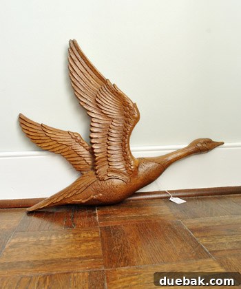 Close-up of a vintage metal goose wall hanging, showcasing its texture and design.