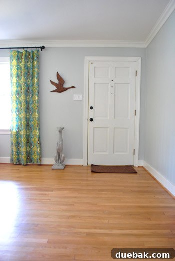 Full view of the vintage metal goose art on the wall, with a concrete greyhound statue beneath it.