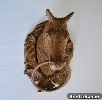 Close-up of a vintage iron horse head wall hanging, featuring a ring below its chin.