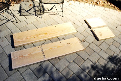Close-up of a wooden shelf board with trim attached and pre-drilled pocket holes on the top surface.