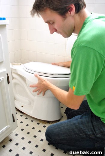 Rock-Solid Toilet: Easy DIY Fix 11 John carefully removing toilet bowl from floor