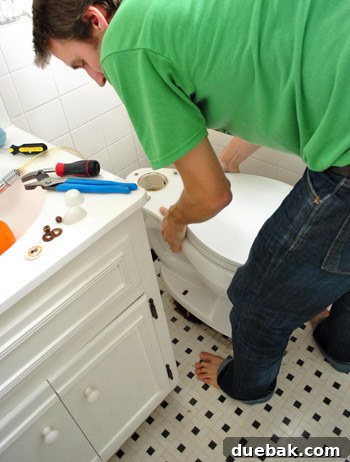 Rock-Solid Toilet: Easy DIY Fix 19 John placing toilet bowl back on floor over new wax ring