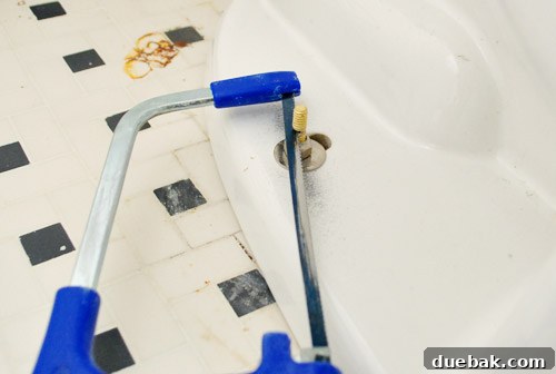 Rock-Solid Toilet: Easy DIY Fix 23 Cutting excess bolt length on toilet bowl with a hacksaw
