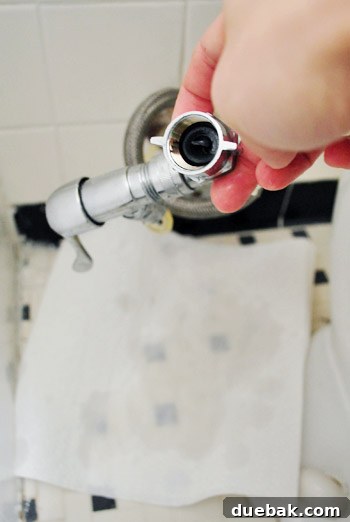Rock-Solid Toilet: Easy DIY Fix 6 Collecting remaining water in toilet supply line with paper towel on the floor