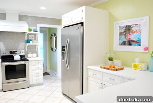 A panoramic view of the kitchen, showcasing the elegant new art print as a central feature above the counter. The image highlights the cohesive blend of modern design, personal touches, and functional aesthetics.