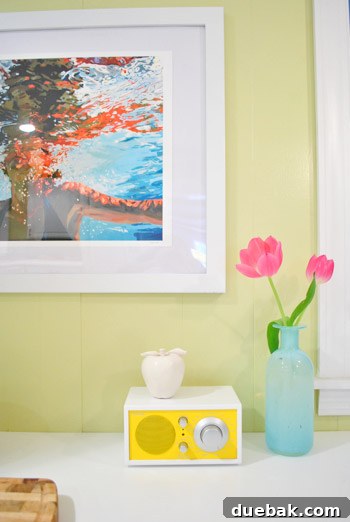 A heartwarming image of a child standing on a chair, gazing intently at the newly framed swimming woman art in the kitchen, perhaps pointing out the imaginary fish she envisioned, embodying pure delight.
