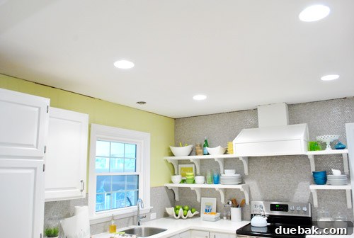 Before crown molding installation, showing an unfinished kitchen ceiling line where wall meets tile