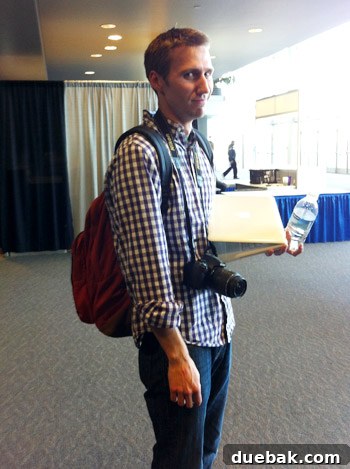 Humorous photo of the author looking nerdy with a large backpack, laptop, and camera at the convention