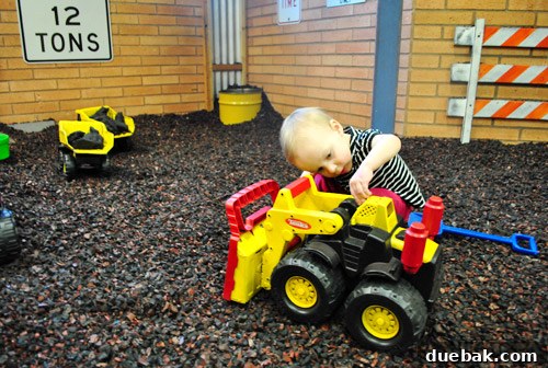 Clara playing with trucks in a rubber gravel pit at the Portland Children's Museum