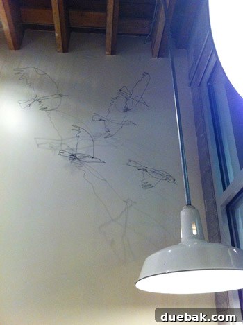 Interior of Salt & Straw, showing wire bird art and industrial decor