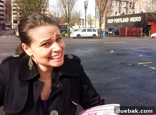 Sherry posing next to a quirky sign, embracing Portland's weird culture