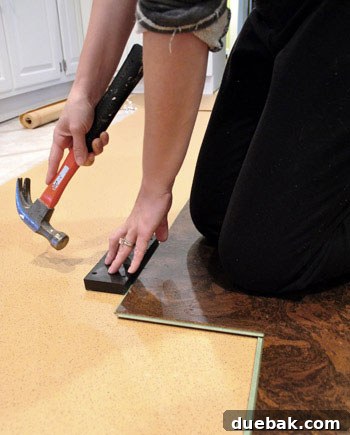 Applying weight to cork plank while tapping