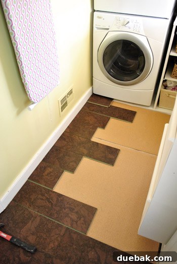 Installing the last few cork planks in a kitchen corner, showing meticulous attention to detail.