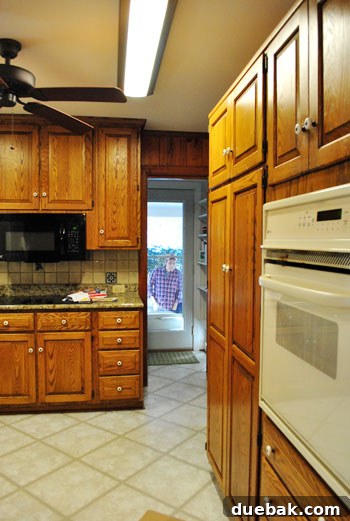 Kitchen space before renovation, depicting its original, outdated appearance.