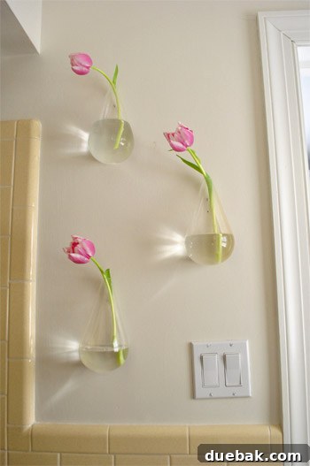 Sculptural Wall Vases 4 Close-up of a single floating vase with a fresh flower, showcasing simple bathroom decor.