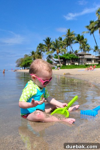 A person stands on a picturesque Maui beach, gazing out at the calm blue ocean.