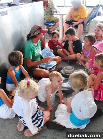 Clara, our toddler, interacting with other children on the whale watching boat, amidst life jackets and excited faces.