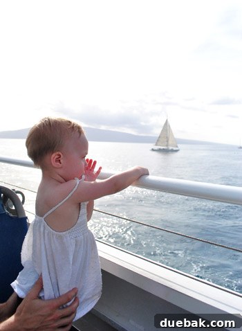 Clara, bundled in a life jacket, playfully interacting with her parents on the whale watching boat.