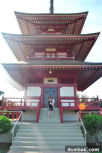 A beautifully ornate Japanese temple building at the Lahaina Jodo Mission, surrounded by lush greenery.