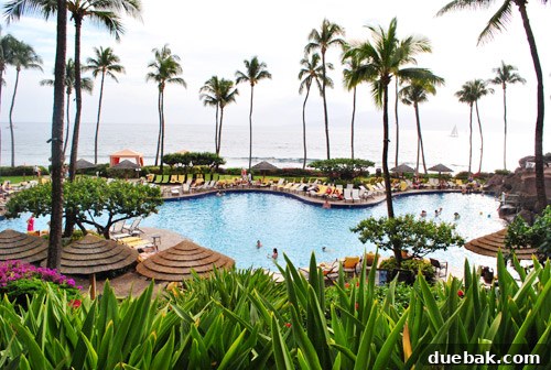 A luxurious resort pool with waterfalls and tropical landscaping, inviting guests to relax.