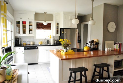 Bright and open kitchen with custom handcrafted wood countertops, elegant pendant lights, and a spacious layout