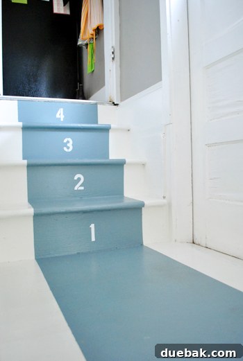 Small staircase with DIY stenciled treads in Benjamin Moore White Dove and Van Cortland Blue, leading to an exterior door