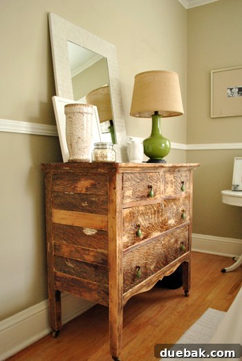 Close-up of the beautifully weathered wood dresser in the guest room, featuring stylish Anthropologie drawer pulls and Behr Pebble Stone walls