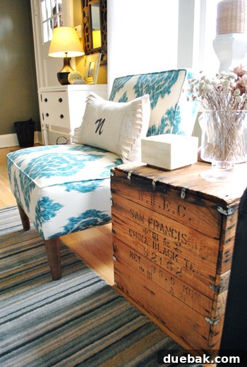 Eclectic living room corner featuring a unique wood chest side table from Craigslist and a vibrant ikat chair from Urban Outfitters