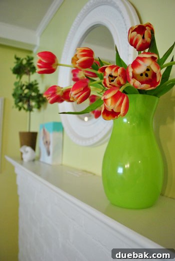 Seasonal Mantel Decor: Christmas, Halloween, and Spring 11 Fresh tulips in a green vase on the kitchen mantel