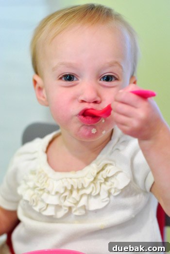 Clara, a young child, eating pastina with a joyful expression