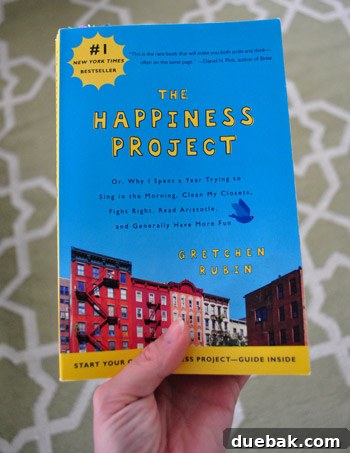 The book 'The Happiness Project' by Gretchen Rubin, lying next to a thoughtful card
