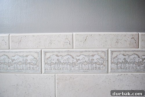Close-up of gray tiles and tree accent tiles complementing the new Rockport Gray wall paint.
