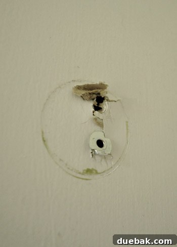 Close-up of metal anchors causing drywall damage.