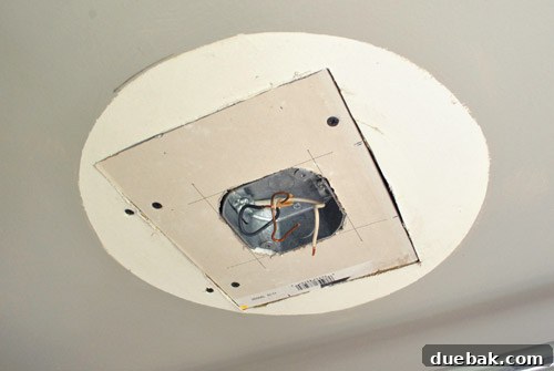 Upgrade Your Boob Light to a Modern Pendant 11 New drywall patch attached to the ceiling, showing screw heads and gaps.