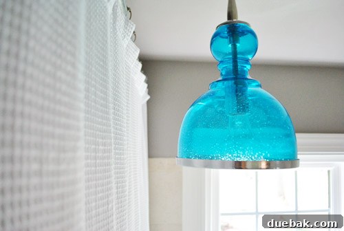 Upgrade Your Boob Light to a Modern Pendant 23 Wider view of the renovated bathroom, including the window and toilet area.