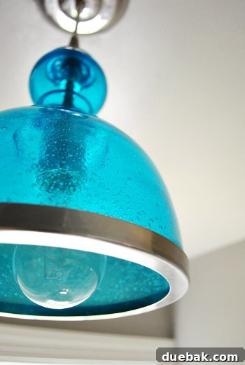 Upgrade Your Boob Light to a Modern Pendant 25 Bathroom corner showing the light switch and door trim, highlighting the color contrast.