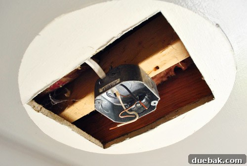 Upgrade Your Boob Light to a Modern Pendant 7 A large, irregularly shaped hole in the ceiling where the old light fixture used to be.