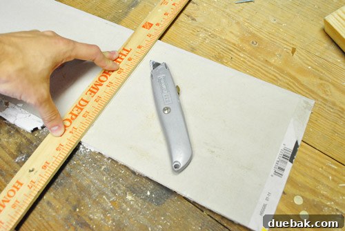 Upgrade Your Boob Light to a Modern Pendant 8 A piece of drywall cut to size, ready for ceiling patch, next to a box cutter.