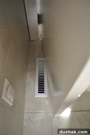 Bathroom Glow-Up on a Budget 9 The bathroom door partially open, showing how it scrapes against a floor grate due to being too low.