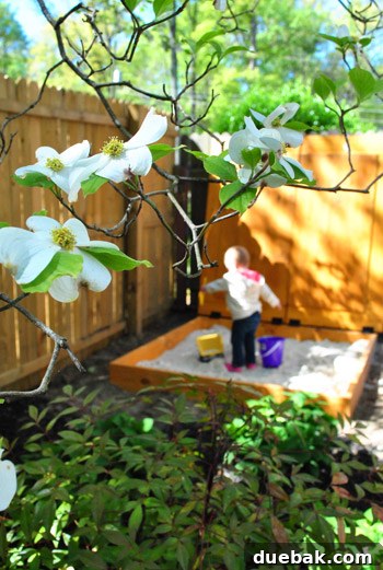 Clara playing happily in the sandbox, showcasing the finished project