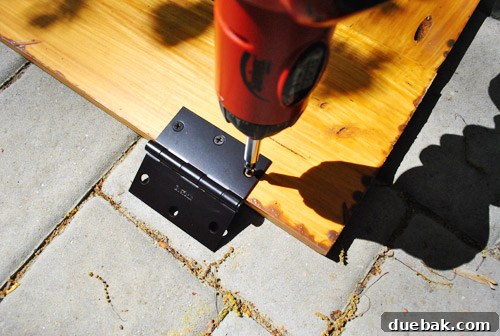 Close-up of a hinge attached to one side of the sandbox cover