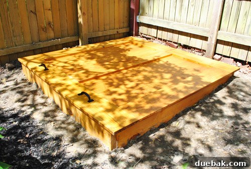 Sandbox with the finished cover attached, under tree shadows