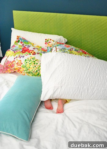 Clara peeking out from behind a pillow made from her custom fabric, engaging in playful hiding.