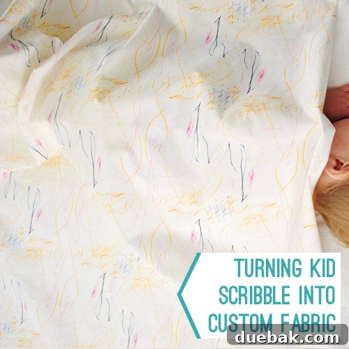 A vibrant, custom-designed fabric featuring abstract scribbles in orange, pink, and navy, laid out flat.