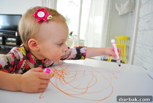 Clara continues drawing, with a serious and concentrated expression, completely absorbed in her artistic activity.